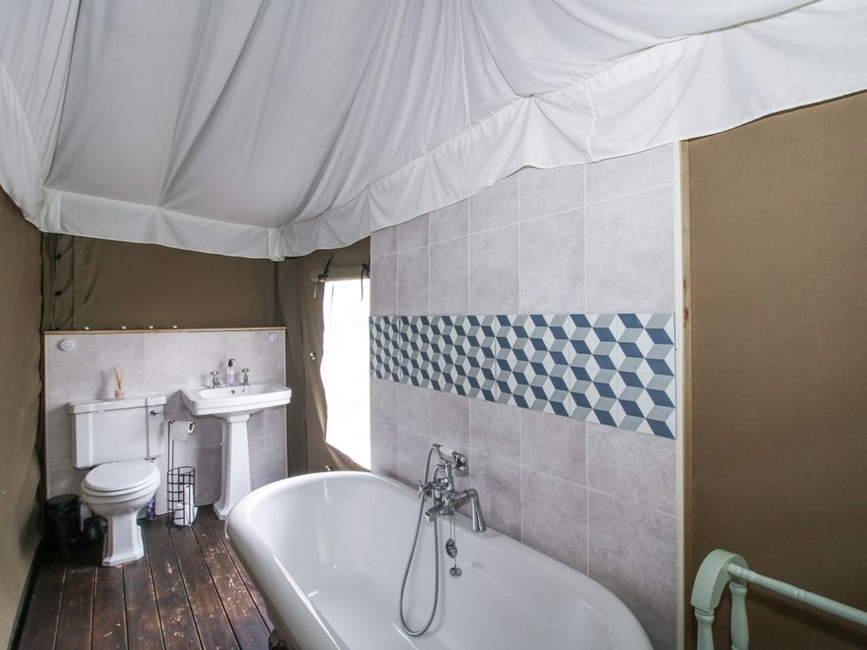 A bathroom with a bathtub, toilet, and sink at Hedgerow in Bewdley