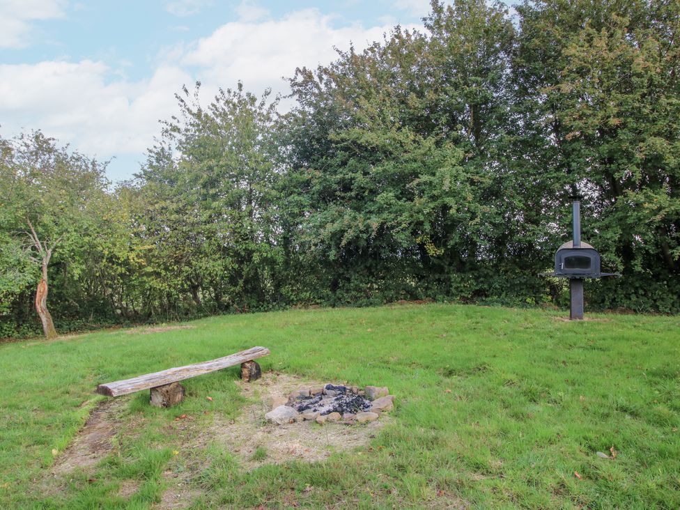 A garden with a fire pit and outdoor oven at Hedgerow in Bewdley
