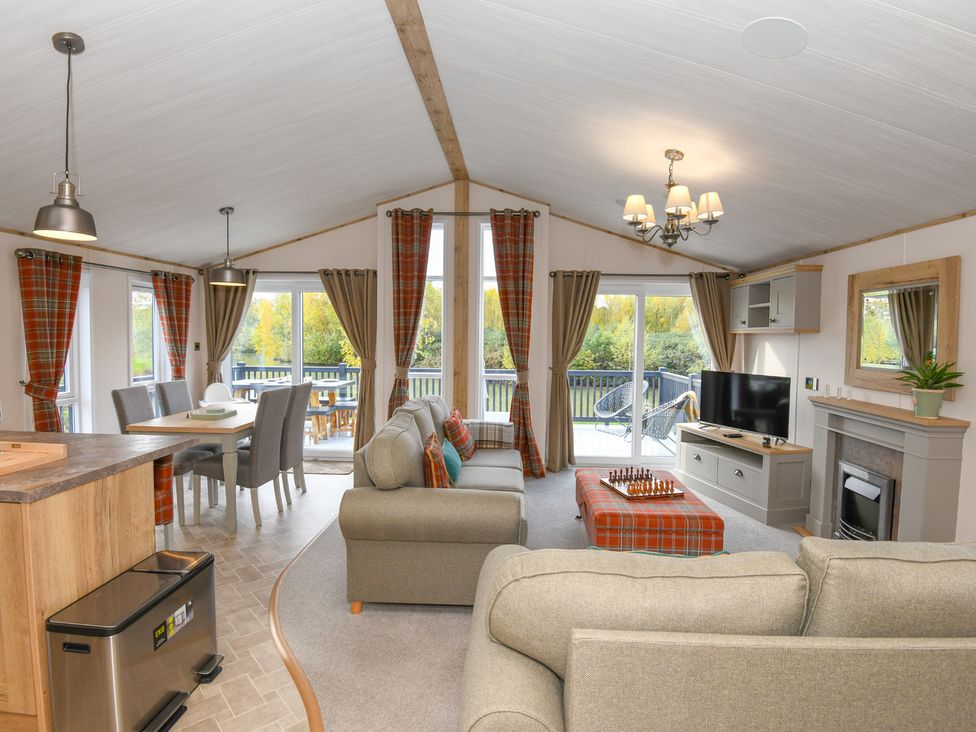 A living room with a sofa and dining table at Lakewood Retreat in Woodhall Spa