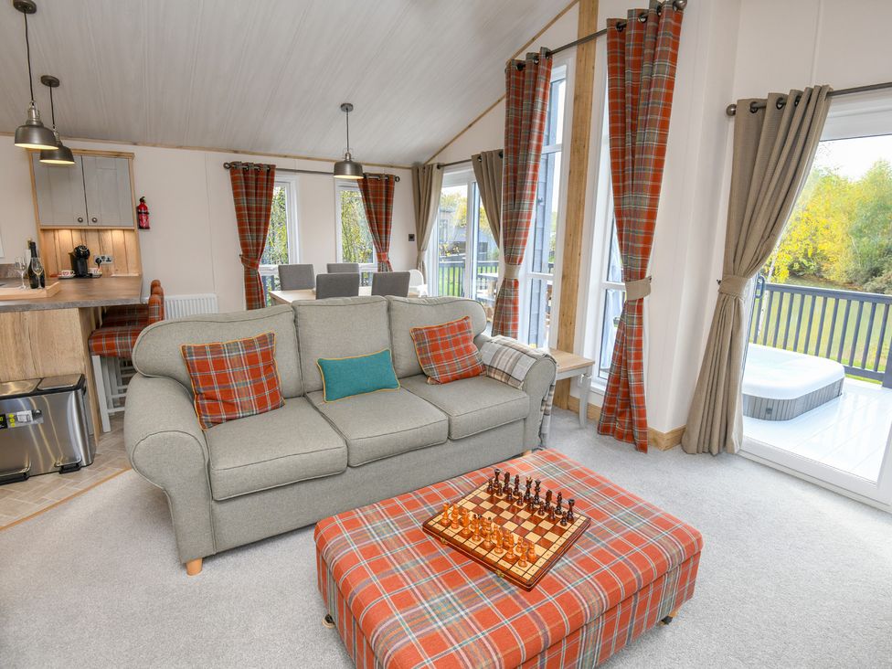 A living room with a sofa and chess board at Lakewood Retreat in Woodhall Spa