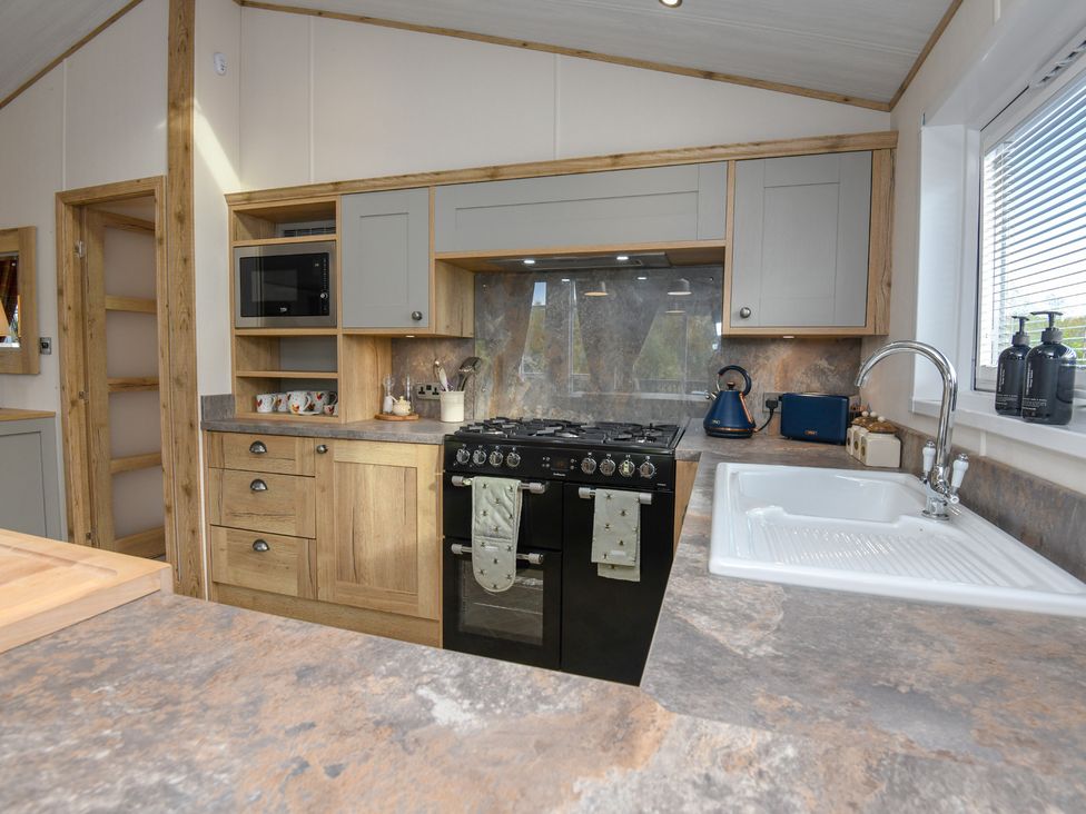 A kitchen with stove and sink at Lakewood Retreat in Woodhall Spa