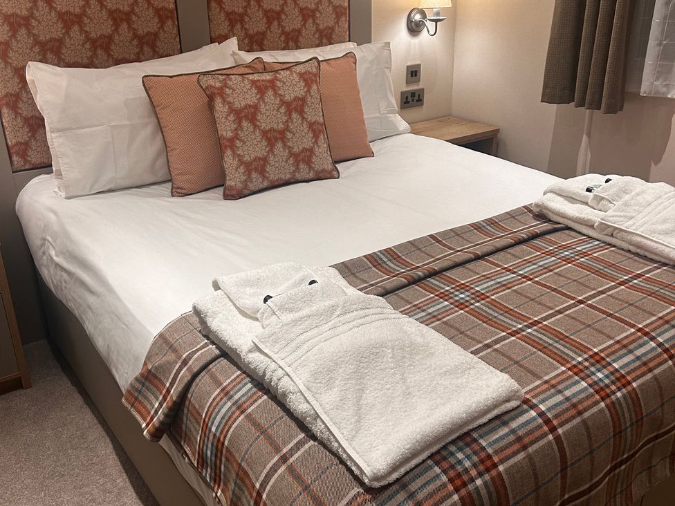 A bed with pillows and blanket at Lakewood Retreat in Woodhall Spa