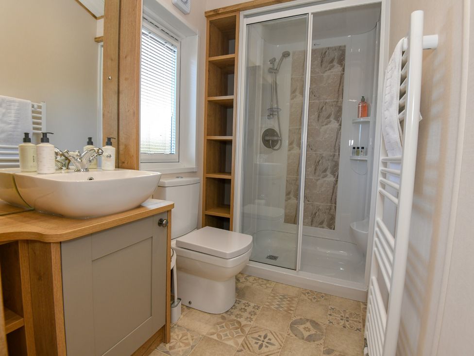 A bathroom with a sink, shower, and toilet at Lakewood Retreat in Woodhall Spa