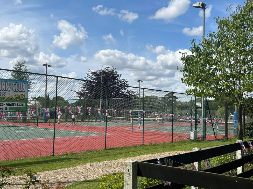 A tennis club with multiple courts and flags at Lakewood Retreat in Woodhall Spa