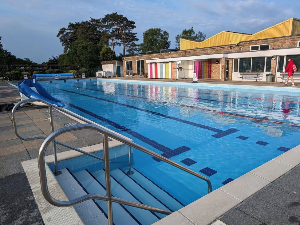 An outdoor swimming pool with a slide at Lakewood Retreat in Woodhall Spa