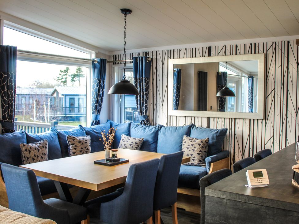 A living room with a sofa and dining table at Hotchkin Lodge in Woodhall Spa