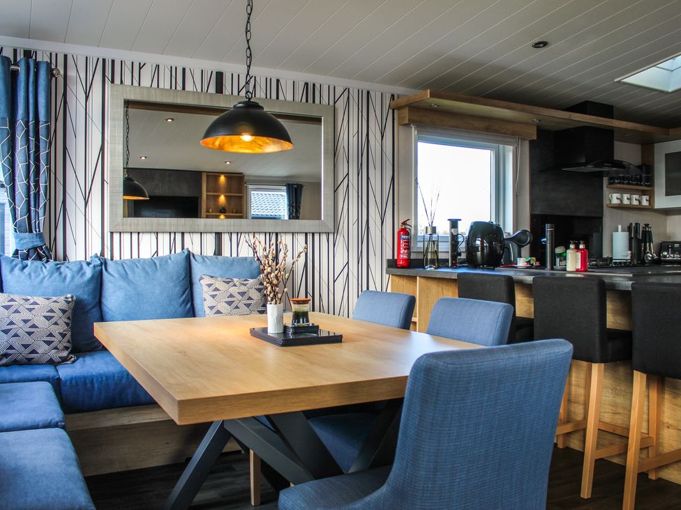 A dining room with a table and chairs at Hotchkin Lodge in Woodhall Spa