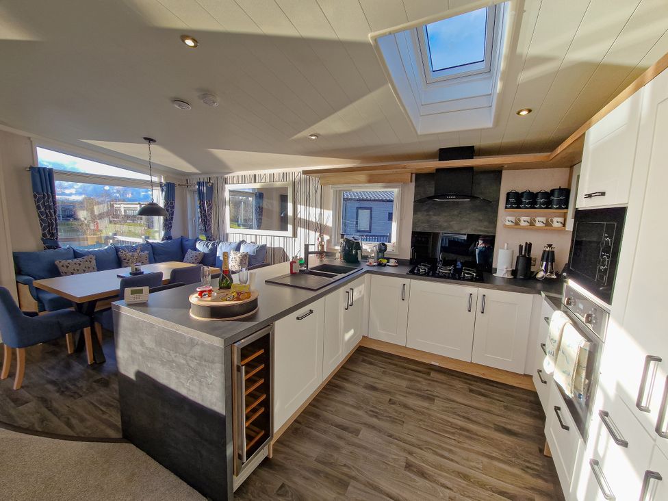 A kitchen with appliances and dining area at Hotchkin Lodge in Woodhall Spa
