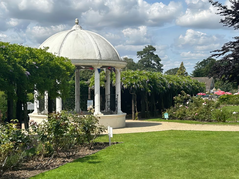 A gazebo surrounded by flowers and hedges at Hotchkin Lodge Woodhall Spa
