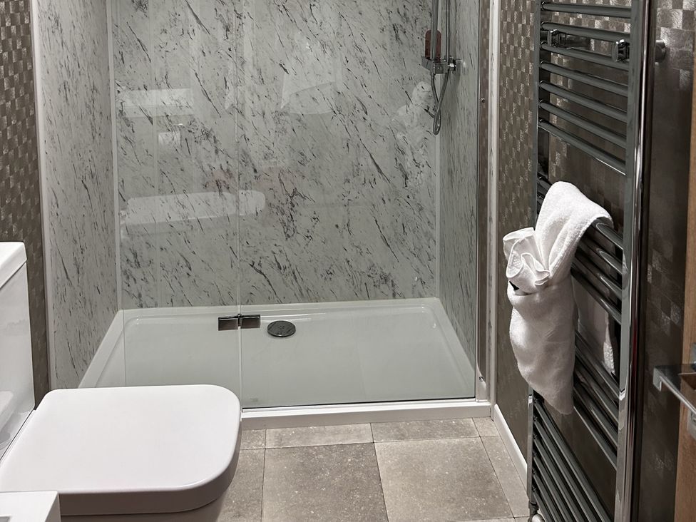 A bathroom with a shower and toilet at Hotchkin Lodge in Woodhall Spa