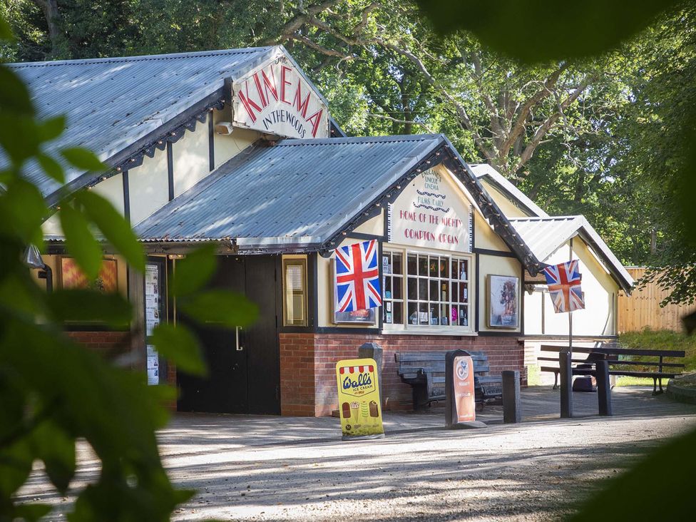 A building with a tin roof and benches at Hotchkin Lodge in Woodhall Spa