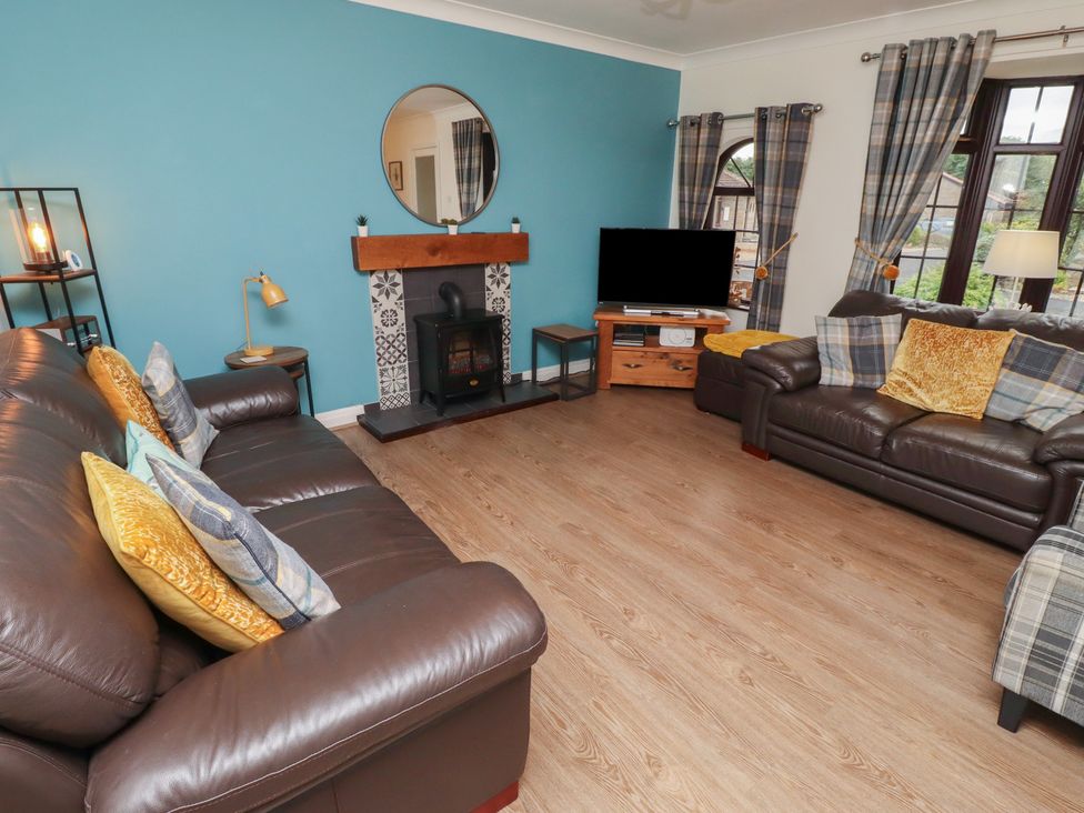 A living room with sofas and a fireplace at Nobles Nook in Seahouses