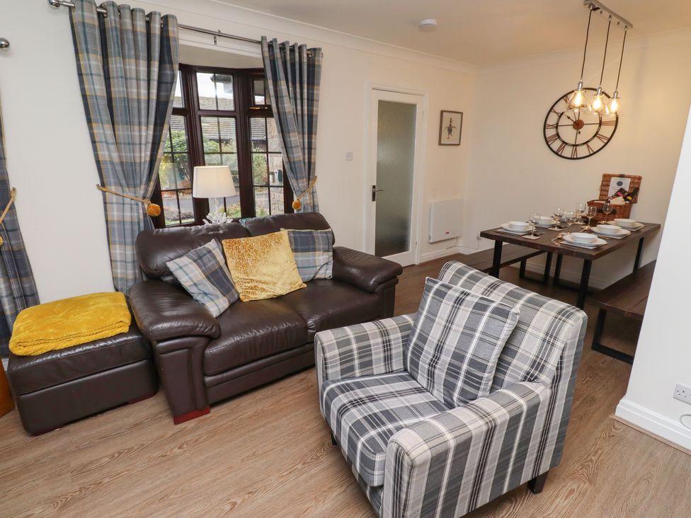 A living room with a sofa and dining table at Nobles Nook in Seahouses