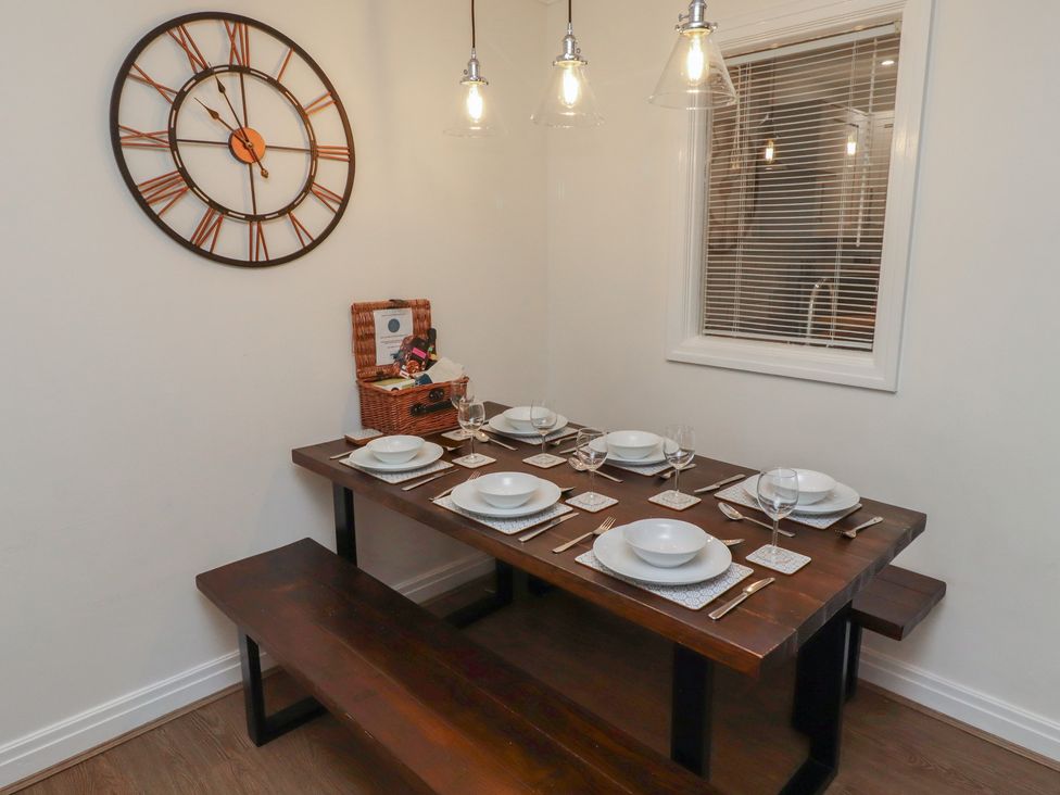A dining room with a table set for dinner at Nobles Nook in Seahouses