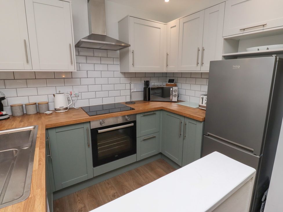 A kitchen with appliances and cabinets at Nobles Nook in Seahouses