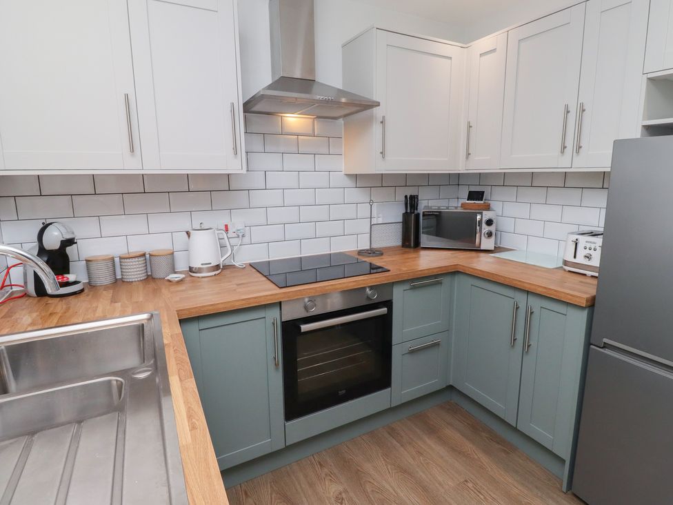 A kitchen with appliances and cabinets at Nobles Nook in Seahouses
