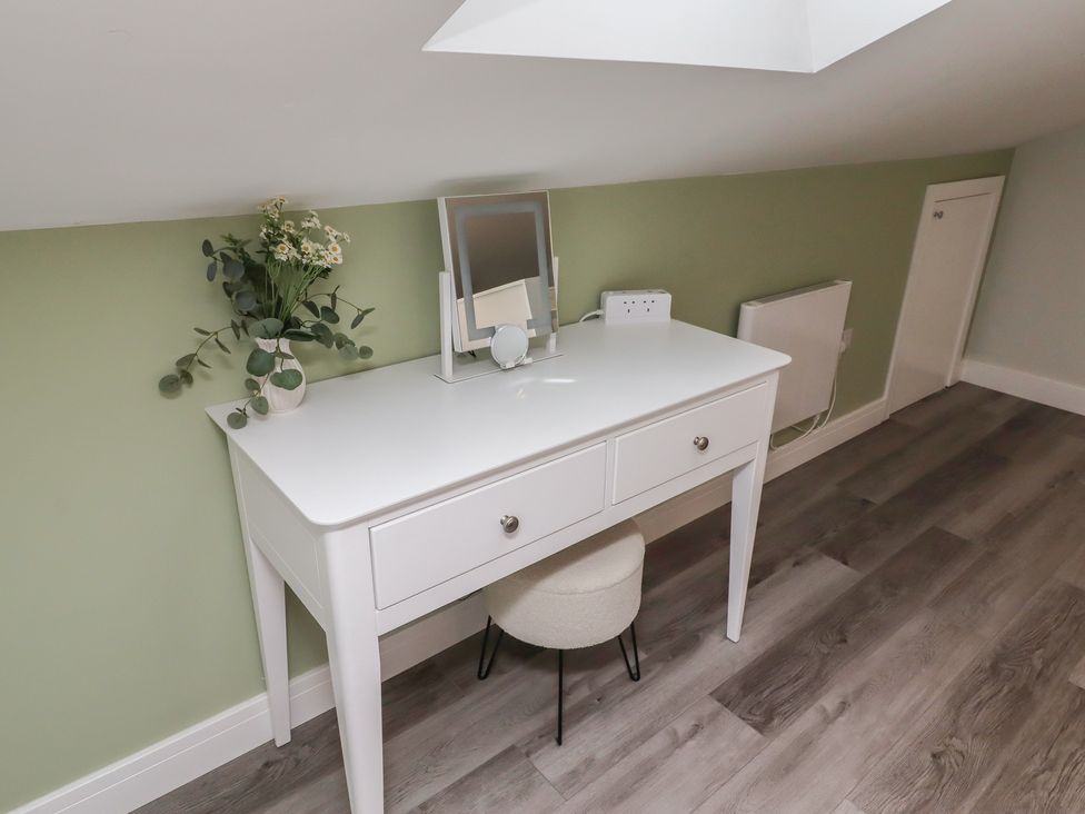 A dressing room with a vanity desk and mirror at Nobles Nook in Seahouses