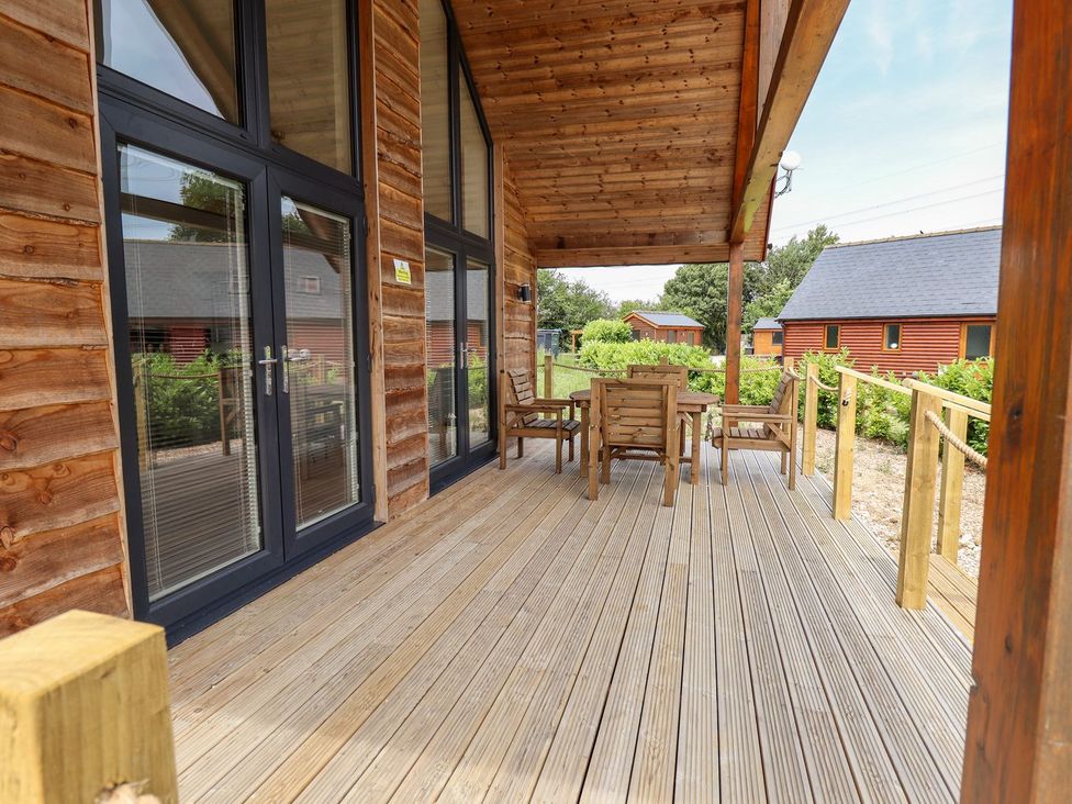 An outdoor patio with wooden table and chairs at Lodge 12 in South Hykeham