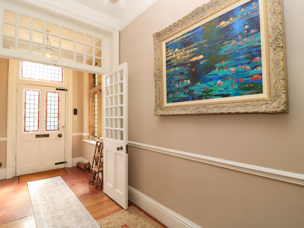 A hallway with a front door and stained glass windows at The Mount in Chippenham