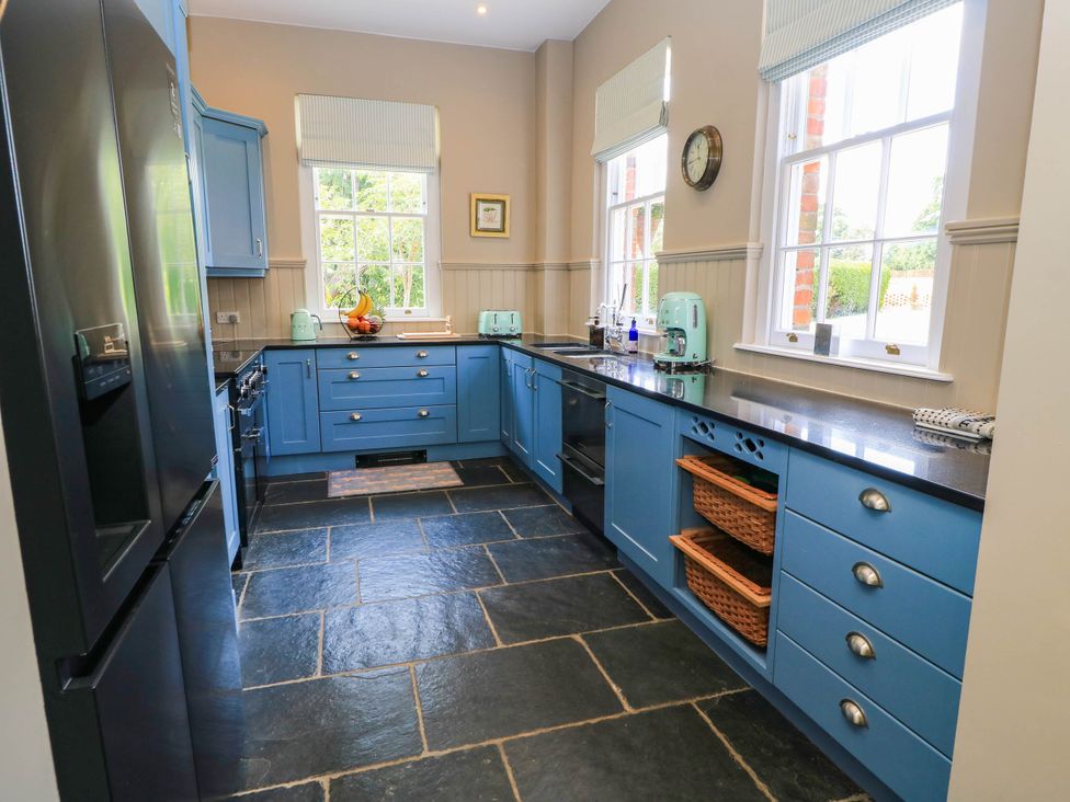 A kitchen with blue cabinets and a sink at The Mount in Chippenham
