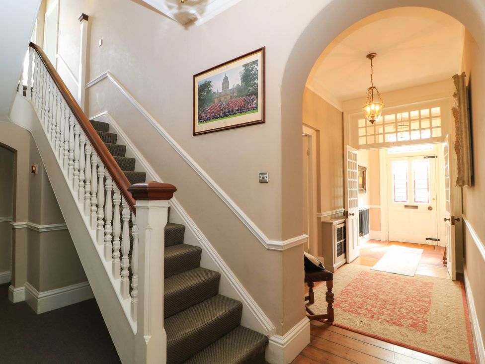 A hallway with a staircase and a door at The Mount in Chippenham