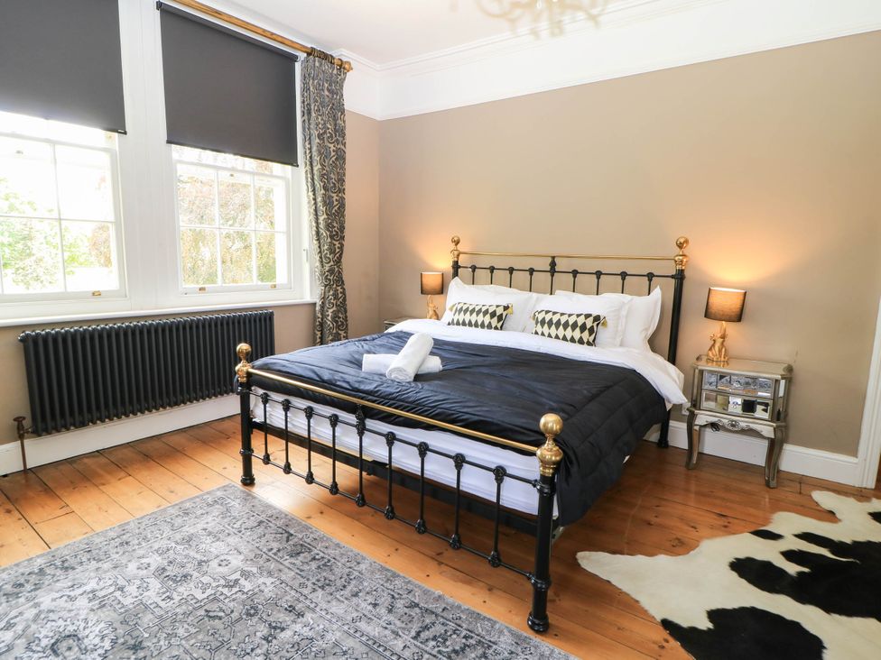 A bedroom with a bed and nightstands at The Mount in Chippenham