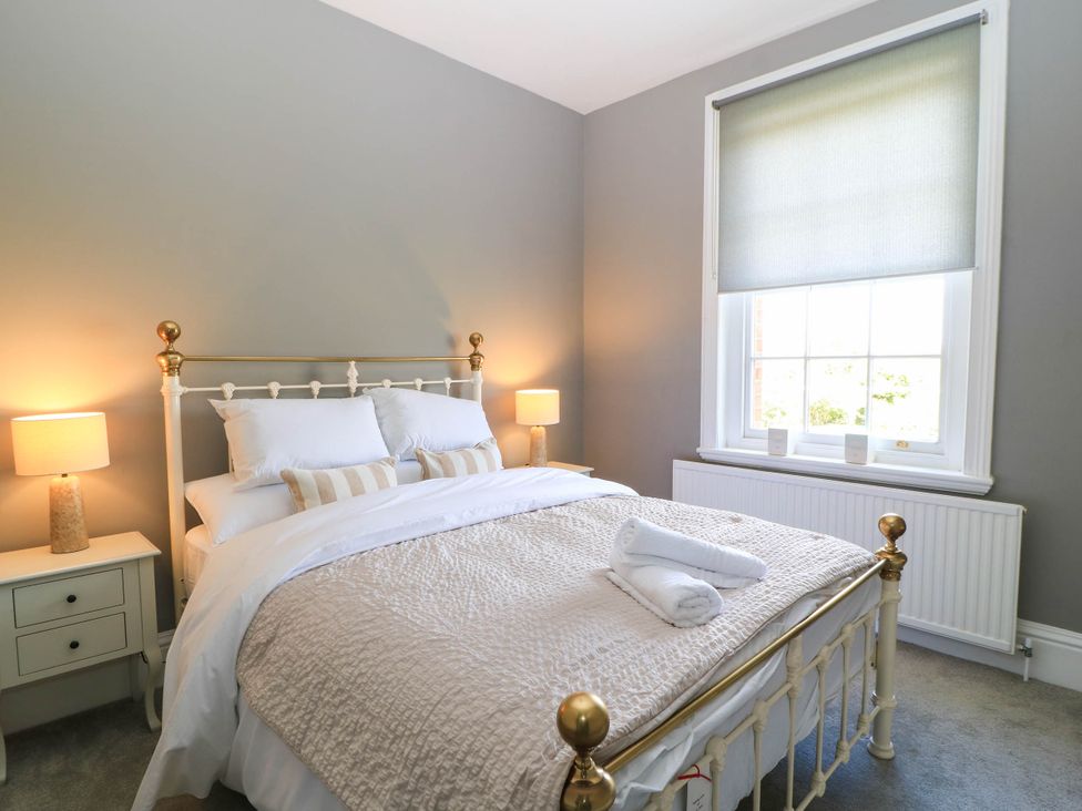 A bedroom with a bed and bedside table at The Mount in Chippenham