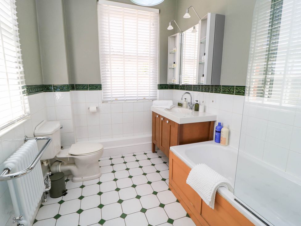 A bathroom with a toilet, sink, and bath at The Mount in Chippenham