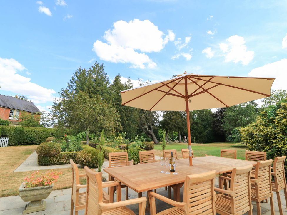 An outdoor dining area with a table and chairs under an umbrella at The Mount in Chippenham