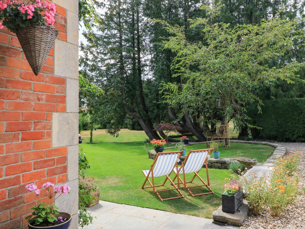 A garden with chairs and flowers at The Mount in Chippenham