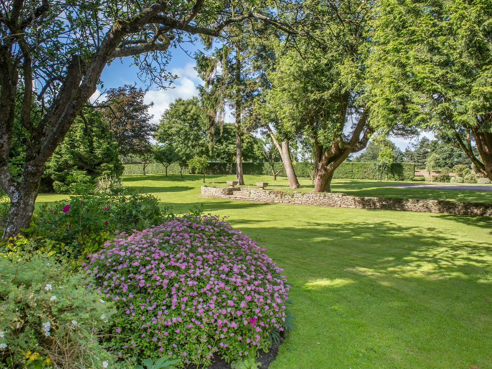 A garden with trees and a flower bed at The Mount Private Estate Upper Seagry