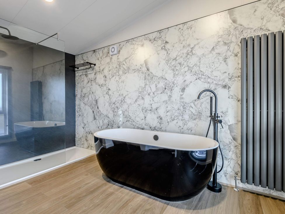 A bathroom with a black bathtub and a shower at Somersby (Pet) in Louth