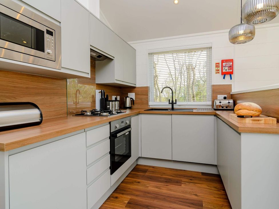 A kitchen with appliances and a workspace at The Woodnewton in Wansford