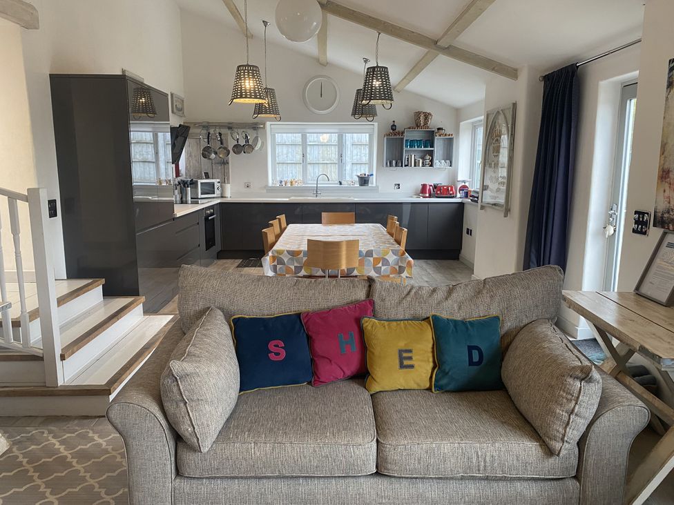 A kitchen with a dining table and sofa at The Cow Shed in Bishopswood