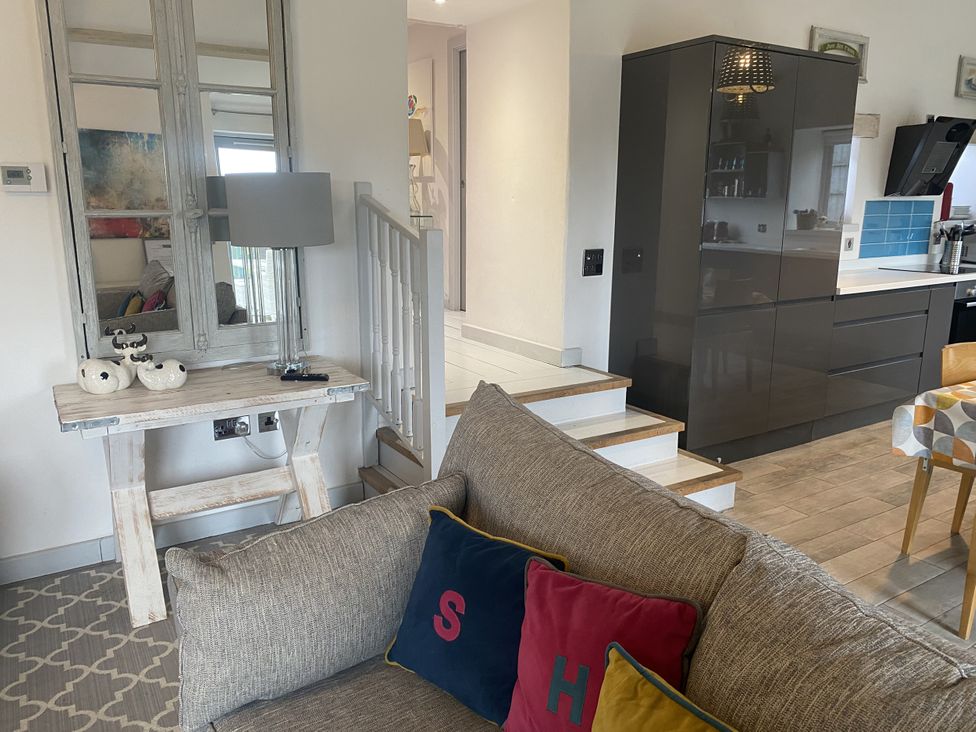 A living room with a sofa and stairs at The Cow Shed in Bishopswood