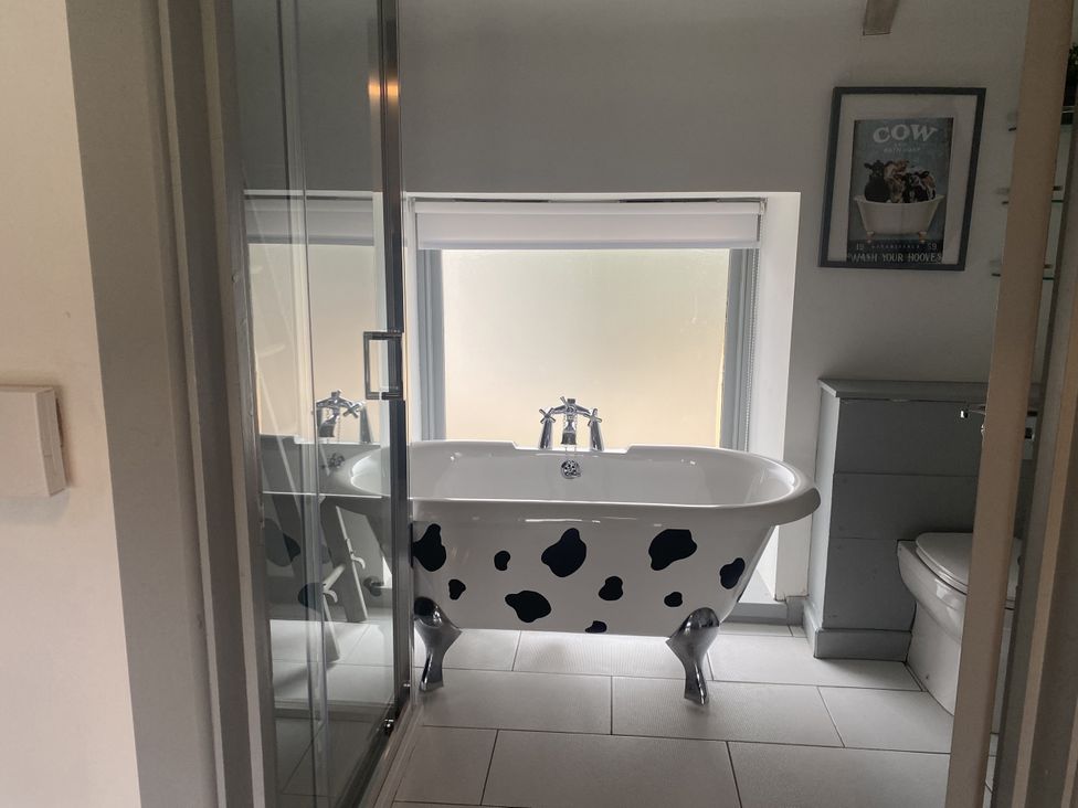 A bathroom with a bathtub, shower, and toilet at The Cow Shed in Bishopswood