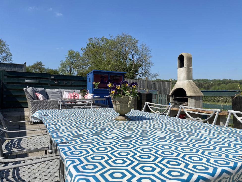 An outdoor seating area with a table and chairs at The Cow Shed in Bishopswood
