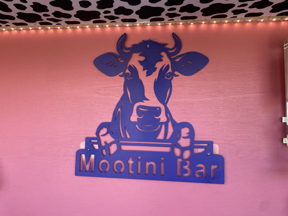 A cow-themed sign for Mootini Bar at The Cow Shed in Bishopswood