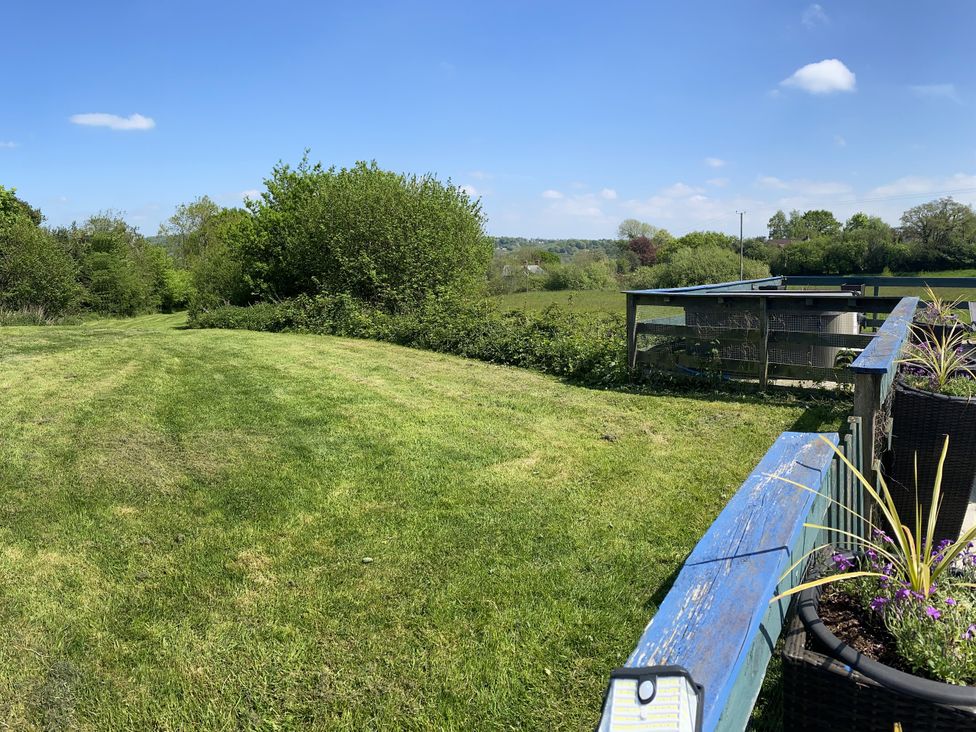 A garden area with grass and trees at The Cow Shed in Bishopswood