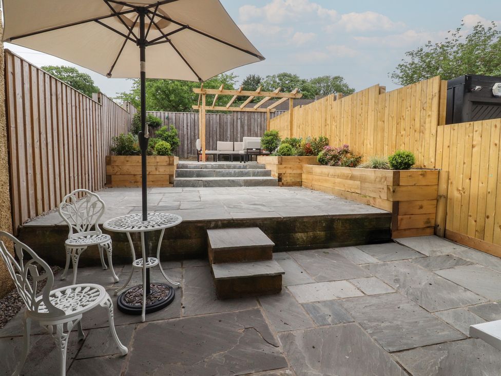 A garden with a table and chairs under an umbrella at 42 Windsor Avenue