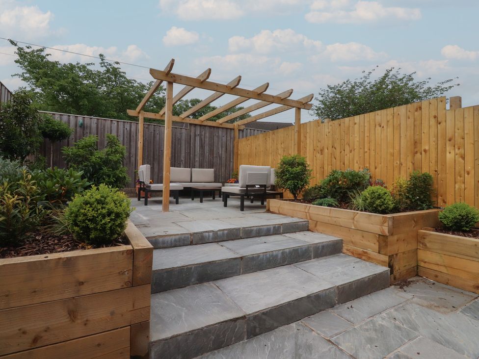A garden with a wooden pergola and outdoor seating at 42 Windsor Avenue