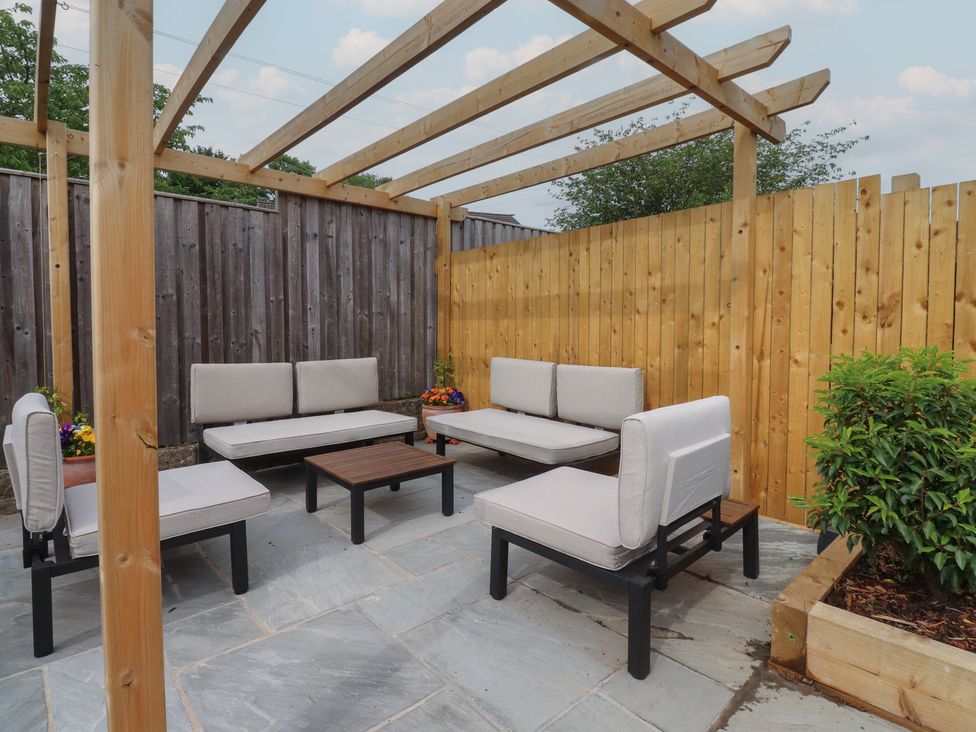 An outdoor seating area with a coffee table and pergola at 42 Windsor Avenue