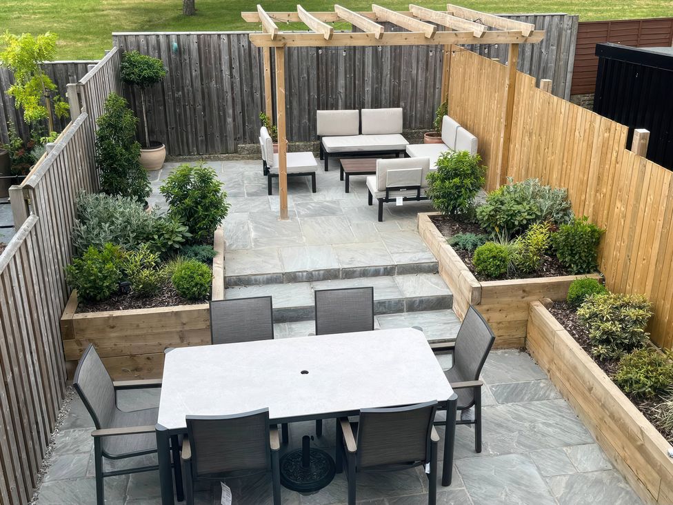A garden with a pergola, outdoor seating and dining area at Shepherd's Lodge in Skipton