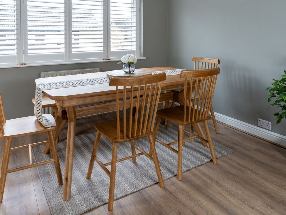 A dining room with a wooden table and chairs at Shepherd's Lodge in Skipton