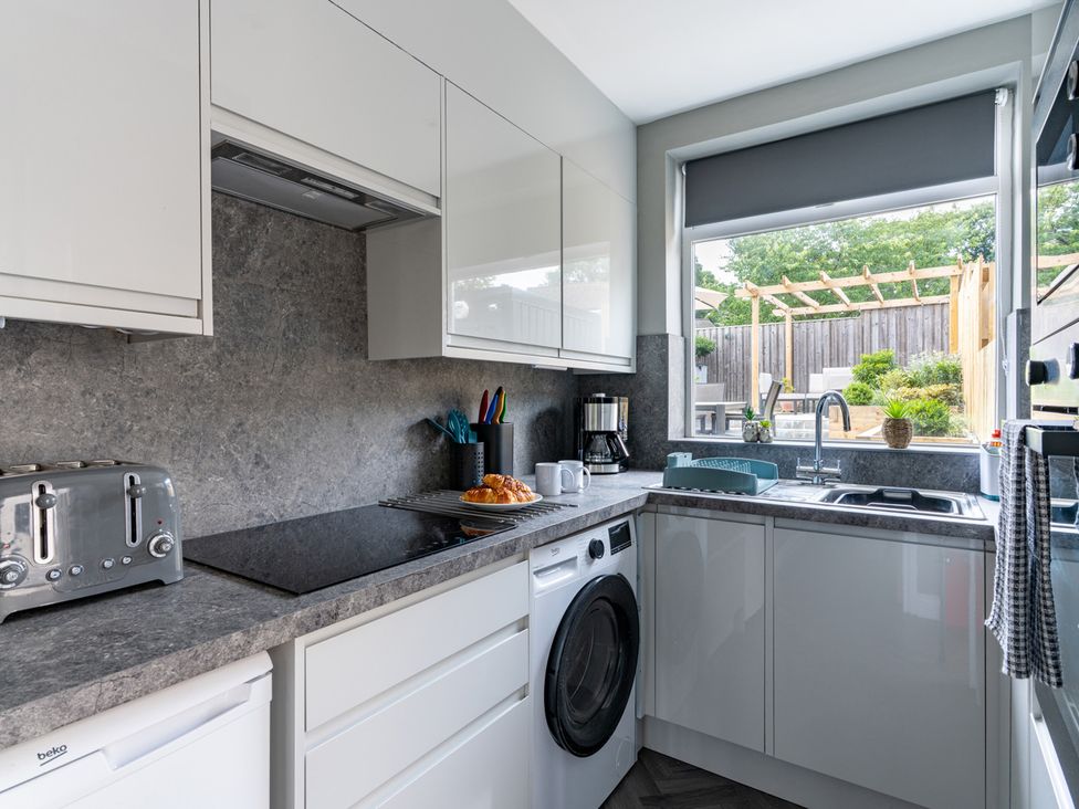 A kitchen with appliances and a view of the garden at Shepherd's Lodge in Skipton