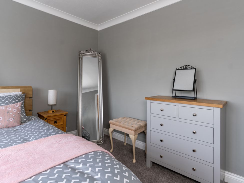 A bedroom with a bed and mirror at Shepherd's Lodge in Skipton