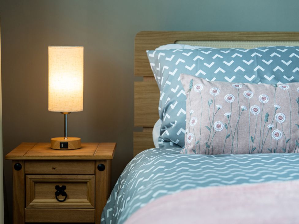 A bedroom with a bed and lamp at Shepherd's Lodge in Skipton