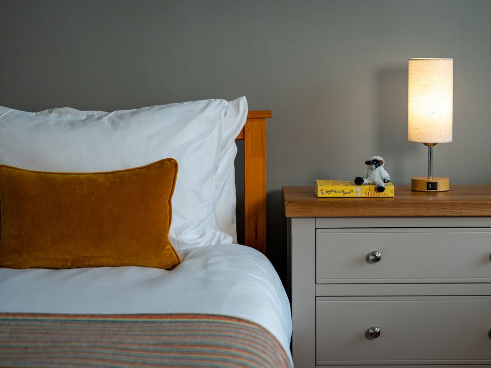 A bedroom with a bed and nightstand at Shepherd's Lodge in Skipton