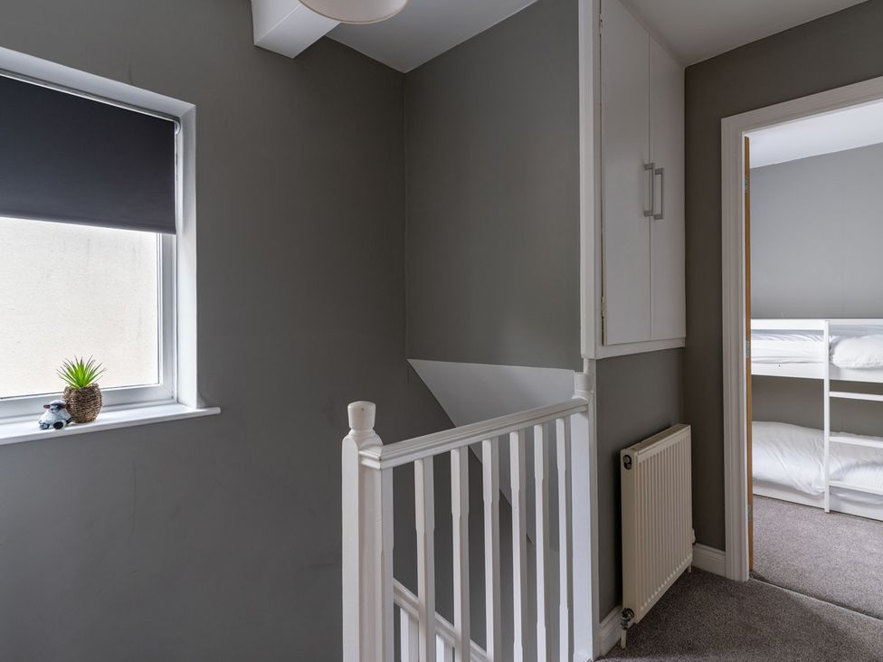 A landing area with a staircase and a window at Shepherd's Lodge in Skipton