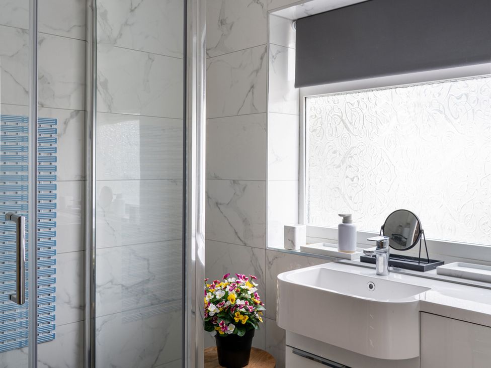 A bathroom with a sink and shower at Shepherd's Lodge in Skipton